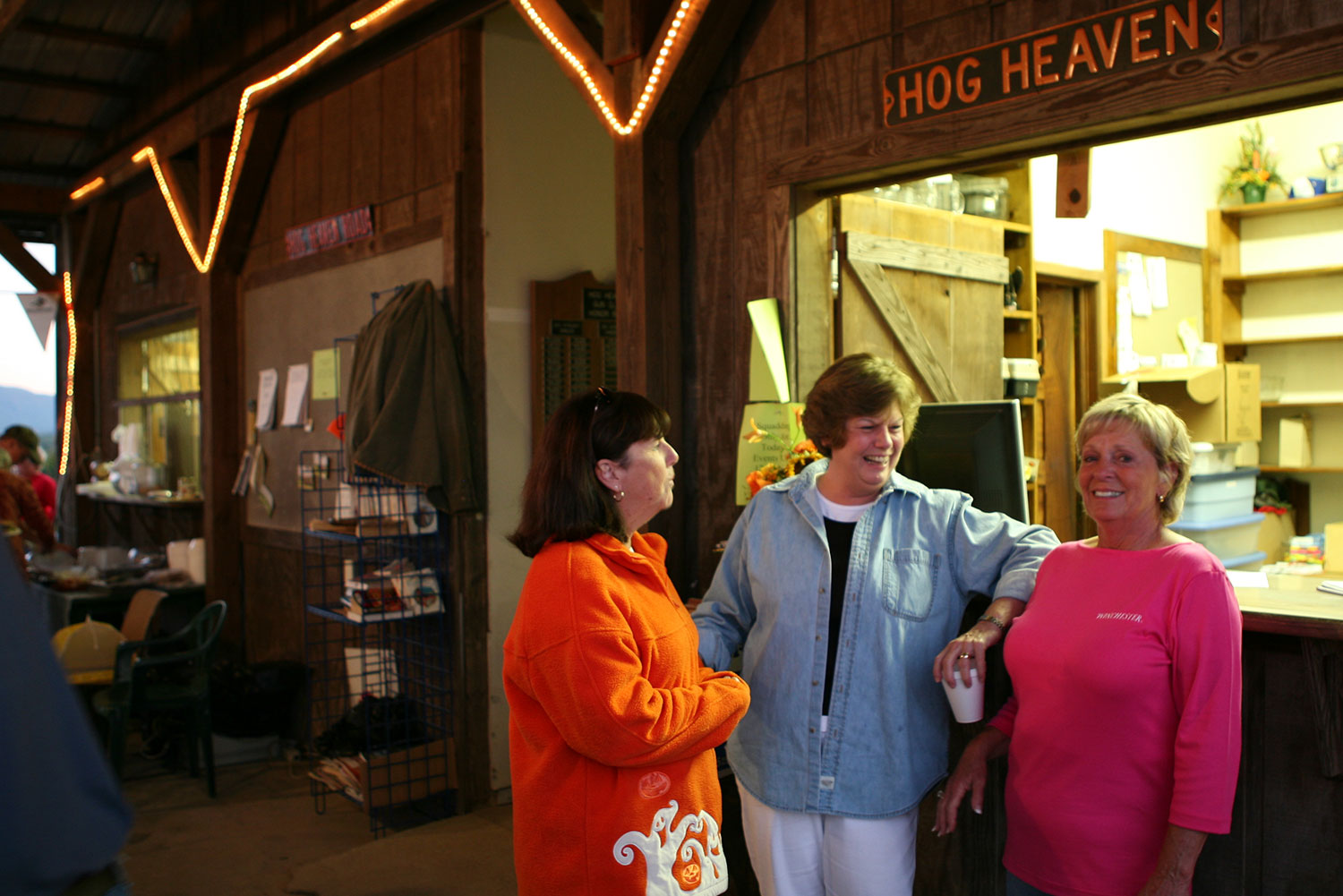 Three women smiling at the Hog Heaven clubhouse window