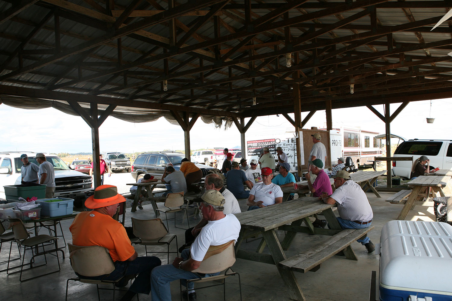 Shooters relaxing at picnic tables inside the pavilion