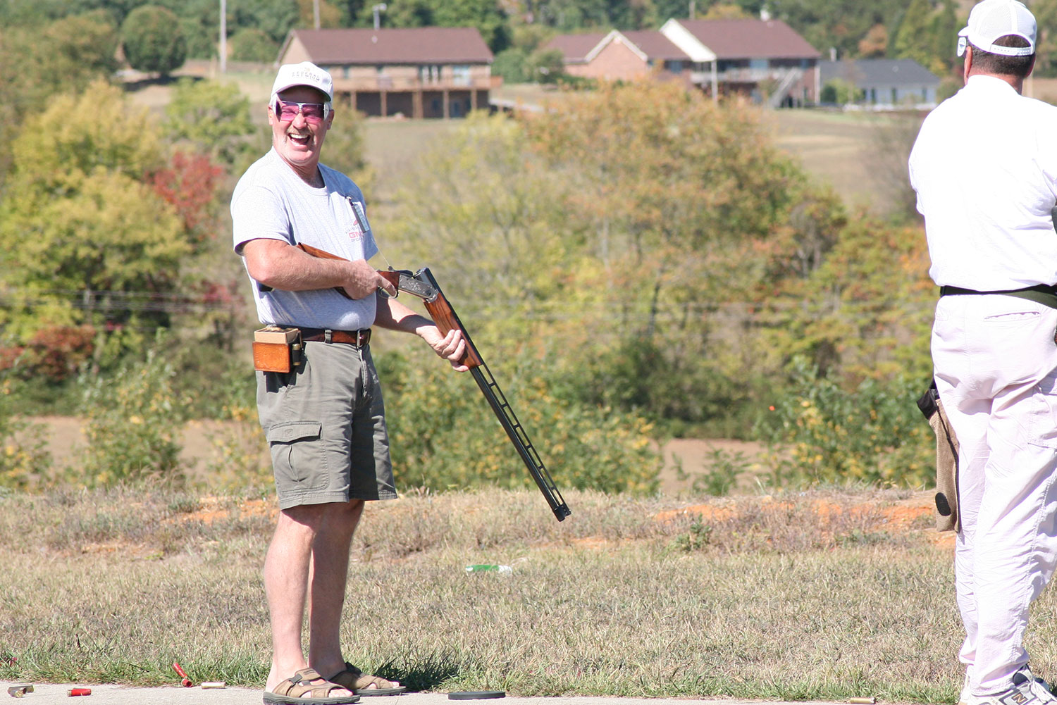 Smiling shooter holding a shotgun on the field