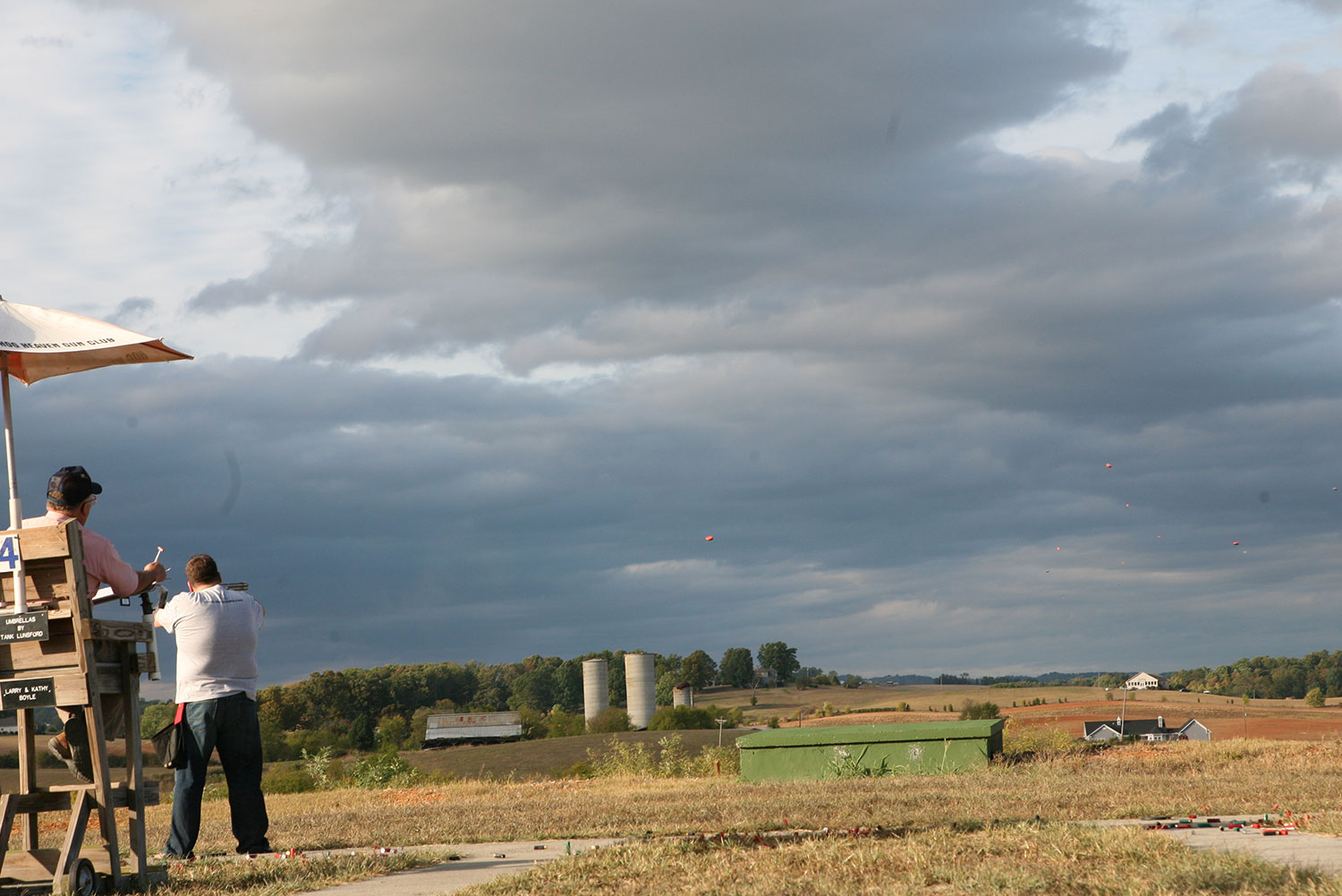 Shooters on the trap line under dramatic clouds