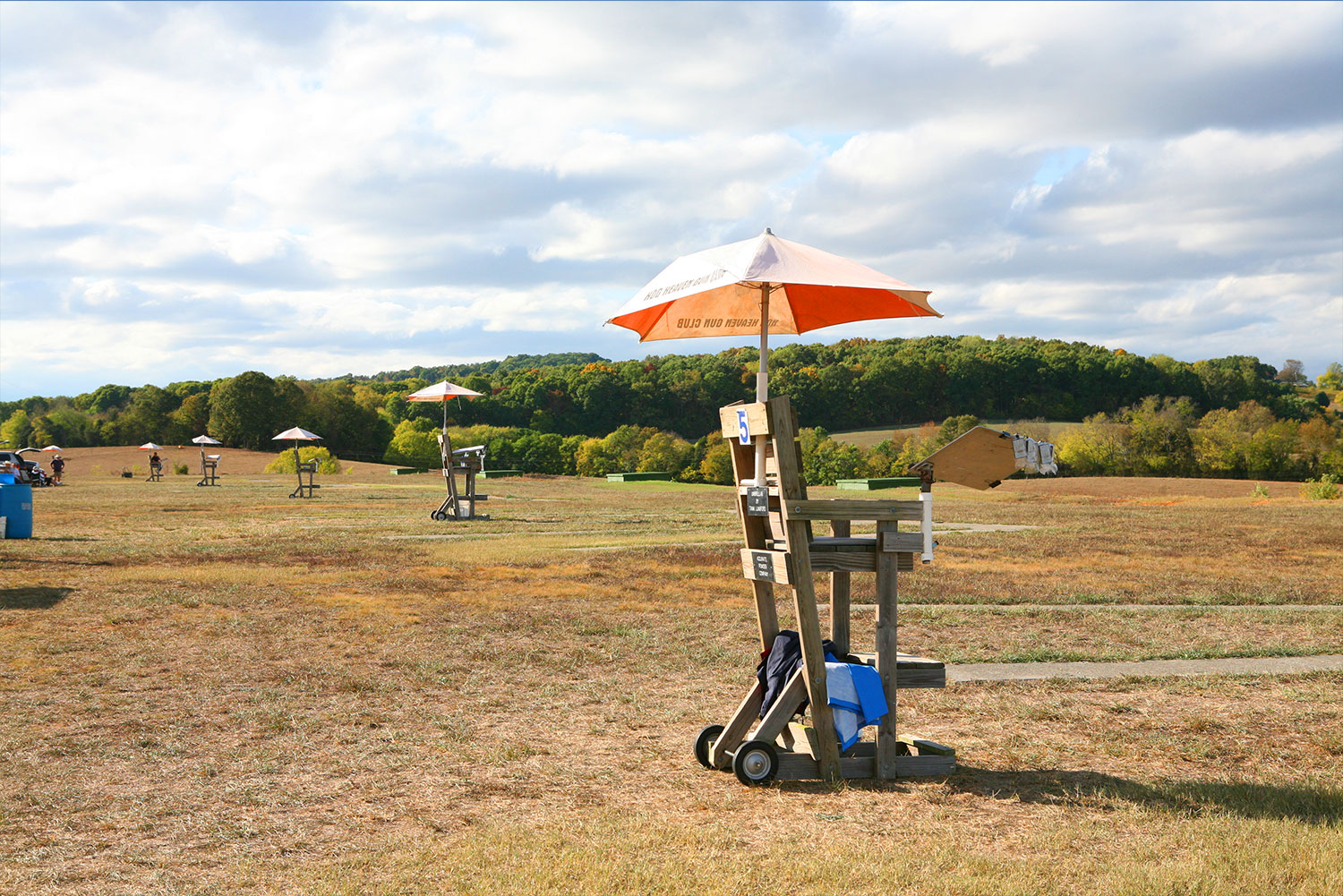 Trap fields with a scorer's chair and orange umbrella